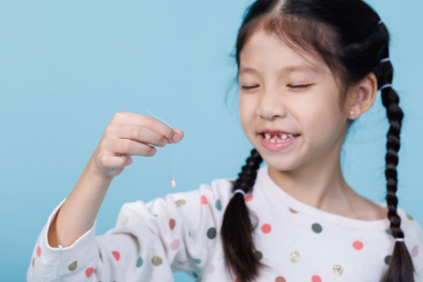 牙齿松动的小女孩微笑的特写，牙科和保健的概念图片下载