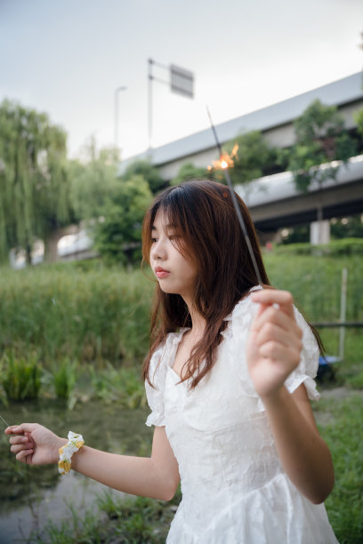 亚洲女孩在晚上燃放烟花图片下载