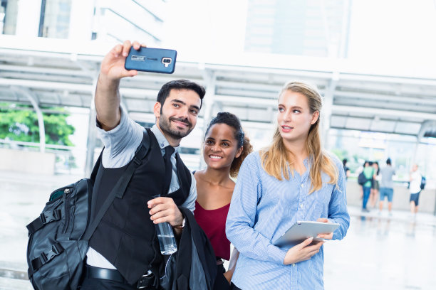 一群商人在社交媒体上更新照片，以显示他们一直在努力工作。图片下载