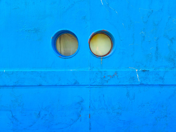 船的亮蓝色金属墙，中间有两个圆形的小窗户图片下载