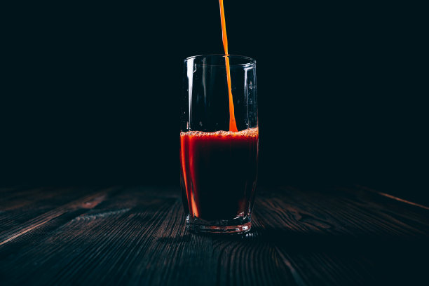 番茄汁倒入一个多面玻璃杯中图片下载