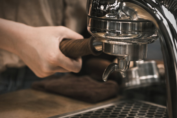 从咖啡机中倒入意式浓缩咖啡。在餐厅、酒吧或酒吧，咖啡机准备新鲜的咖啡，并倒入红色的杯子。煮咖啡图片下载