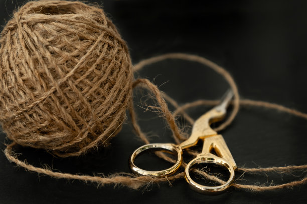 粗麻绳拧成球和剪刀在黑暗的桌面近距离图片下载