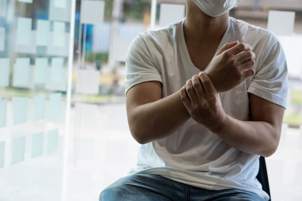 人的手有腕部疼痛，因肌肉僵硬而疼痛。在椅子上受苦图片下载