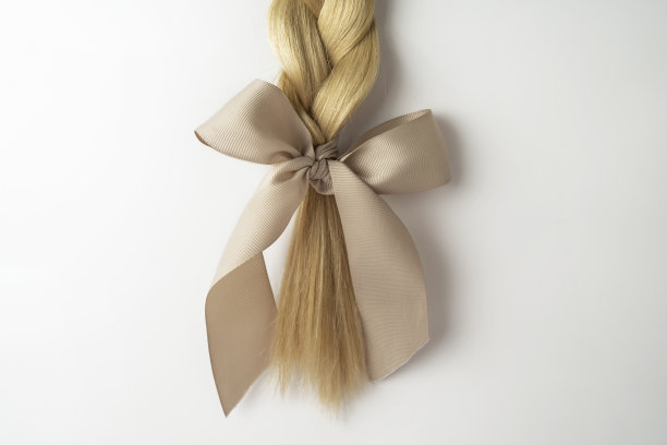 一缕金色的头发躺在白色的背景上图片下载