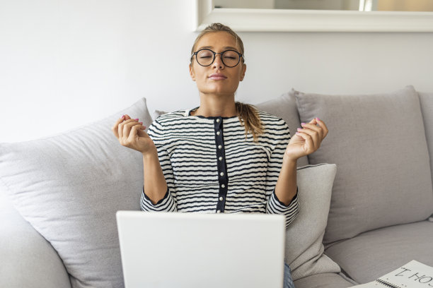 一个年轻的女商人正在用笔记本电脑冥想。图片下载