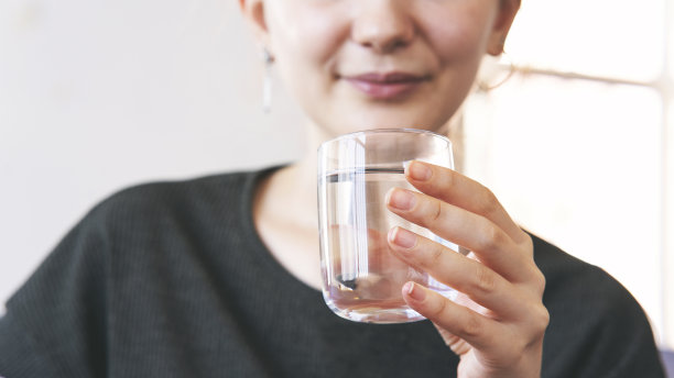 妇女在家里喝着一杯新鲜的水图片下载