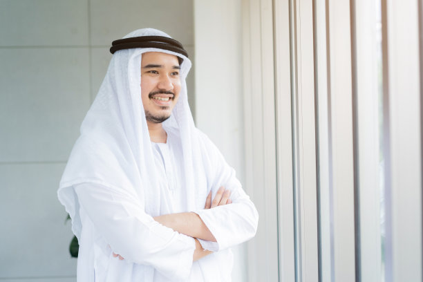 阿拉伯商人微笑交叉双臂的正面特写图片下载