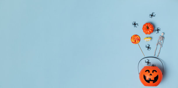 蓝色背景的万圣节南瓜桶杰克灯笼。横幅平铺拷贝空间俯视图图片下载