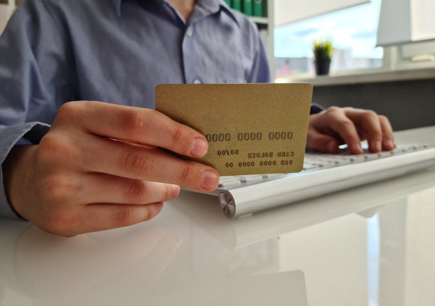 在线支付，一个商人手里拿着信用卡，用笔记本电脑网购图片下载