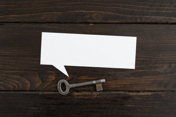 语音泡沫的空白纸与关键躺在木制背景。业务概念锁定您的重要数据，策略和信息，为业务的成功。图片下载