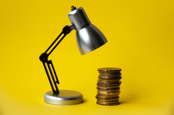 以台灯为背景的金币特写。企业关注的概念图片下载