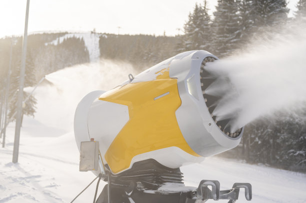 冬天山上的雪炮。喷着人造冰晶的雪枪。机器使雪。图片下载