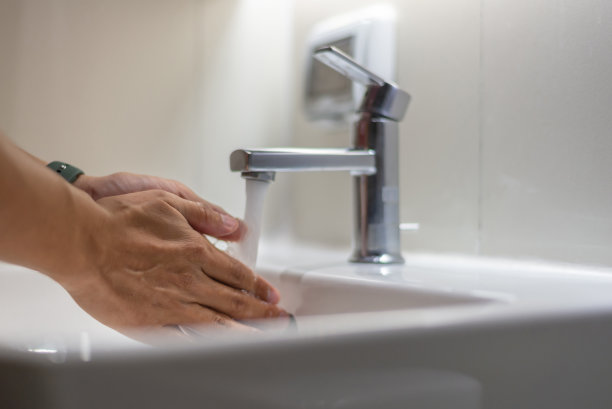 特写图片，在浴室的水槽里用肥皂和清水洗手。经常用肥皂和水洗手有助于减少病毒和细菌。图片下载