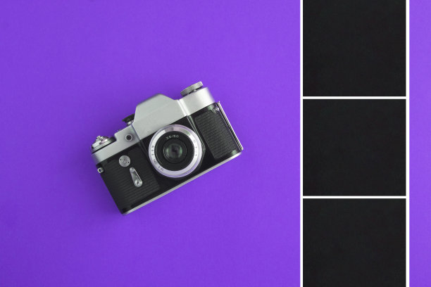 旧相机和黑色方块的照片或文字在紫色的背景。前视图。副本的空间。图片下载