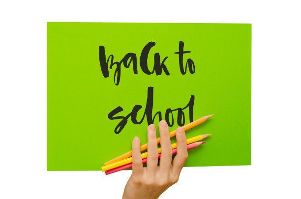 女孩手里拿着一张彩色海报。手写铭文回到学校。孤立在白色图片下载