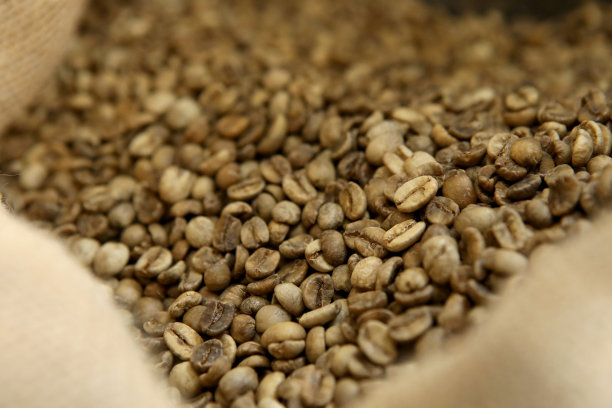 创新的咖啡烘烤器。咖啡是在一台生产机器上用高科技烘焙的。大缸里有很多咖啡。图片下载