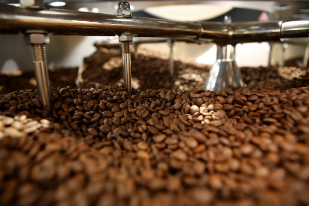 创新的咖啡烘烤器。咖啡是在一台生产机器上用高科技烘焙的。大缸里有很多咖啡。图片下载