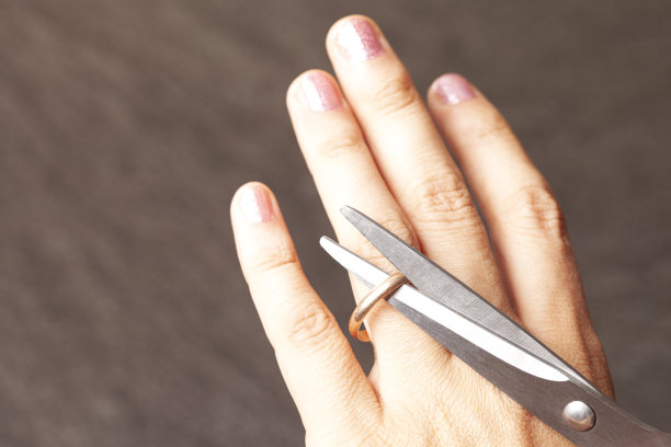 女人的手在用剪刀剪订婚戒指图片下载