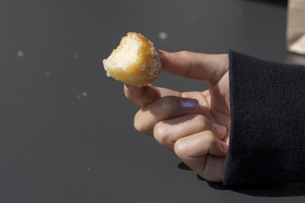 咬了一半的肉桂糖奶油蛋糕甜甜圈洞图片下载