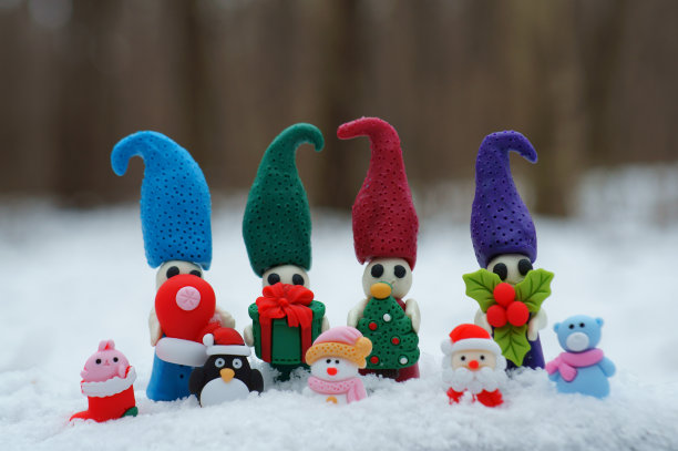 四个小矮人的雕像，手里拿着圣诞装饰品。图片下载