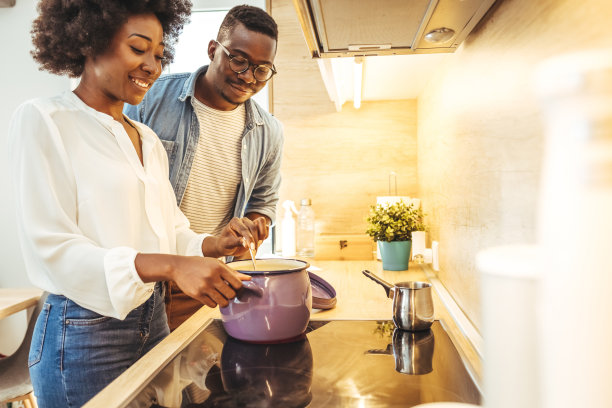 一对年轻夫妇在家里一起做饭的照片。图片下载