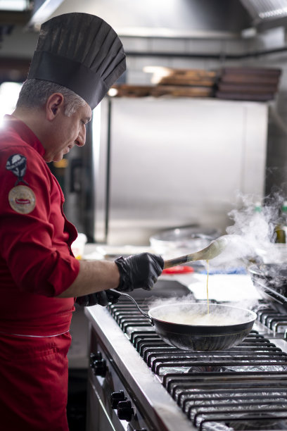 厨师在燃烧的煤气炉上准备食物图片下载