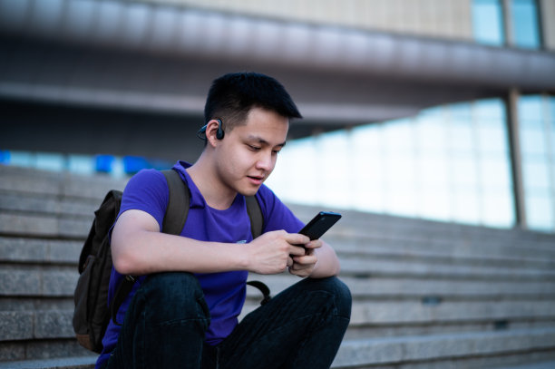 在大学校园使用智能手机的亚洲成年学生图片下载
