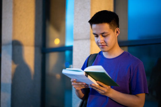 亚洲成年学生在大学校园里阅读图片下载