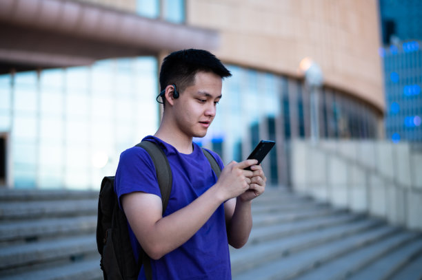 在大学校园使用智能手机的亚洲成年学生图片下载