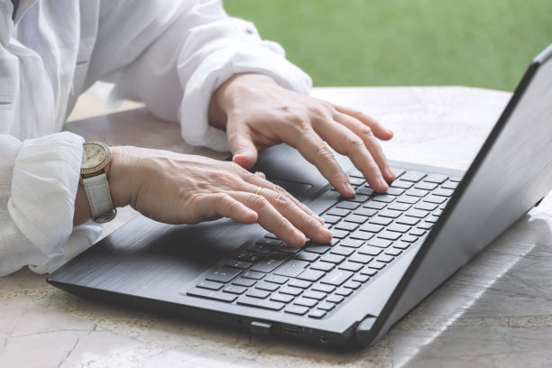 成年女性将手提电脑放在家里的白色八角形大理石桌上图片下载