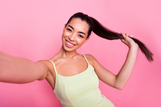 迷人可爱的女人穿黄色连衣裙的照片记录自己的视频孤立的粉红色背景图片下载