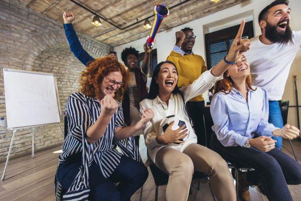 快乐的休闲商务人士或在电视上观看足球比赛庆祝胜利的球迷。友谊、体育、娱乐理念。图片下载