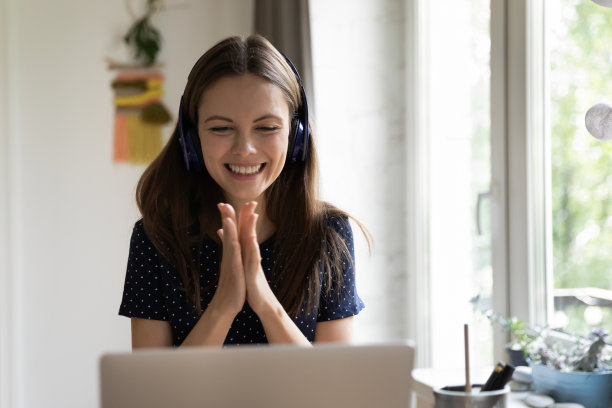 快乐快乐的笔记本电脑用户女孩在无线耳机享受幸运图片下载
