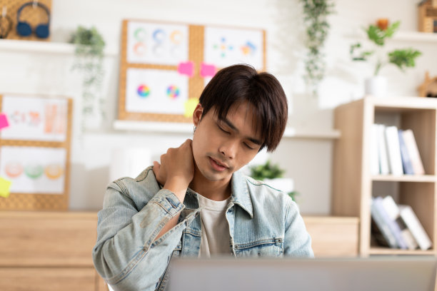 亚洲男性在家工作时脖子和肩膀疼痛。过度劳累后颈部肌肉紧张。办公室综合症的概念图片下载