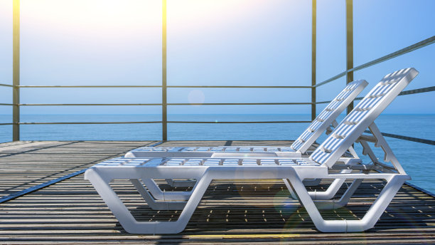 两个空荡荡的白色躺椅排在豪华热带度假酒店。从高码头俯瞰海景。暑假和休假，旅游和旅游的概念。图片下载