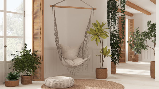 乡村白色客厅，配有藤条盆栽和花边吊椅。带木制百叶窗和镶木地板的窗户。那种波西米亚风格的室内设计图片下载