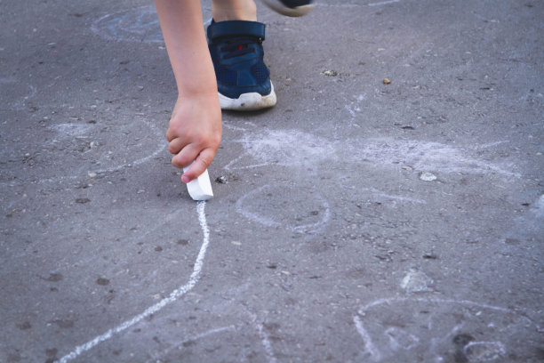孩子们在路上用粉笔画画。孩子们在街上的创造力。图片下载