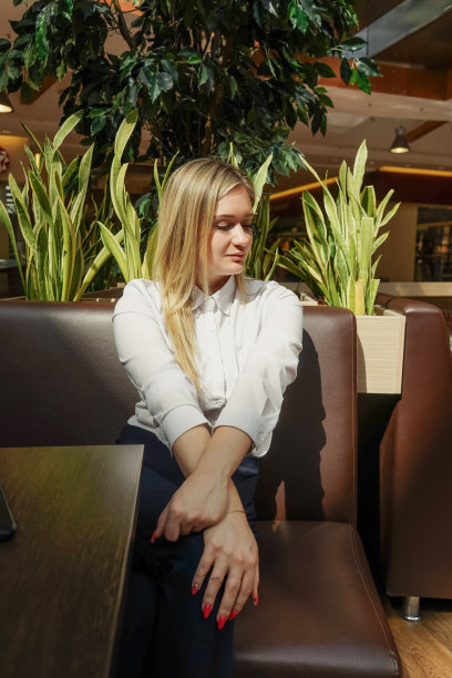 微笑的女人在阳光咖啡馆等咖啡。图片下载