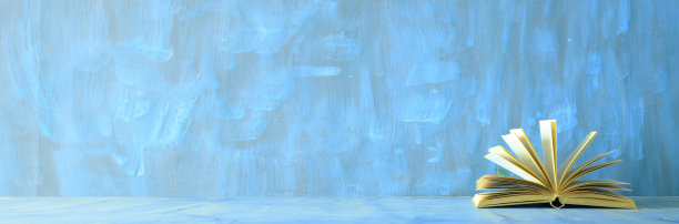 打开书，蓝色背景的经典精装书。教育，读书，学习，居家办公理念。图片下载