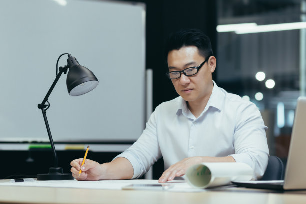 亚洲设计师在现代办公室设计蓝图图片下载