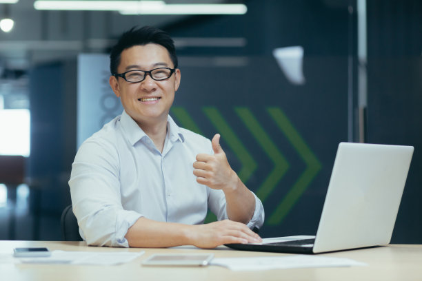 成功的亚洲商人在办公室的肖像，男人用笔记本电脑工作图片下载
