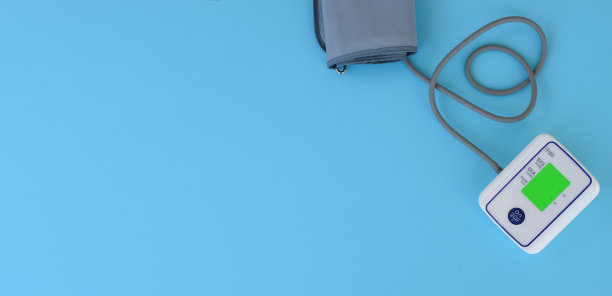 从蓝色医学背景的眼压计脐带用心脏自动测量血压的装置。头痛，治疗高血压、低血压。副本的空间。医学概念旗帜。图片下载