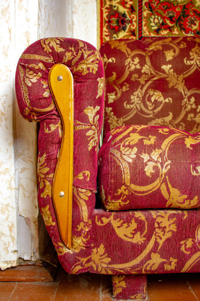 古老的古董木制沙发，上面覆盖着红色图案的织物。一张老式沙发的侧壁。古董罕见的沙发。图片下载