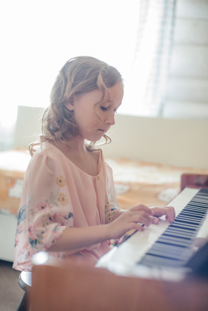 这个女孩弹钢琴。图片下载