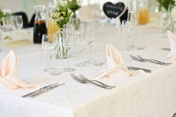 豪华婚宴上的桌子。漂亮的花在桌子上。端盘子，玻璃杯，服务员工作图片下载