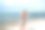 夏天的照片金发快乐的女人放松在海滩上，微笑。穿着短牛仔裤的女孩有着健美的棕色身体。图片下载