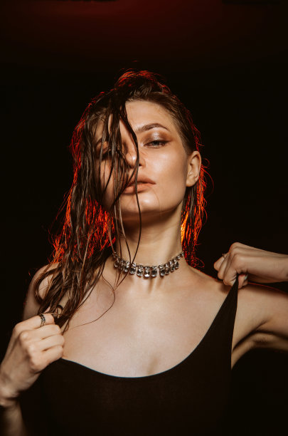 在黑色背景上摆姿势的美女图片下载