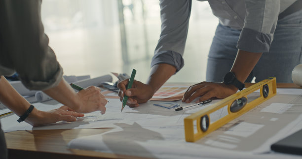 商务人士正在起草一份建设计划。创造性的建筑师头脑风暴和规划改造设计使用蓝图。设计人员正在为工作绘制详细的图画图片下载