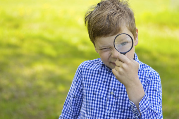 一个小男孩用放大镜探索自然。好奇的孩子们在森林里度过暑假。徒步旅行。未来的科学家植物学家图片下载